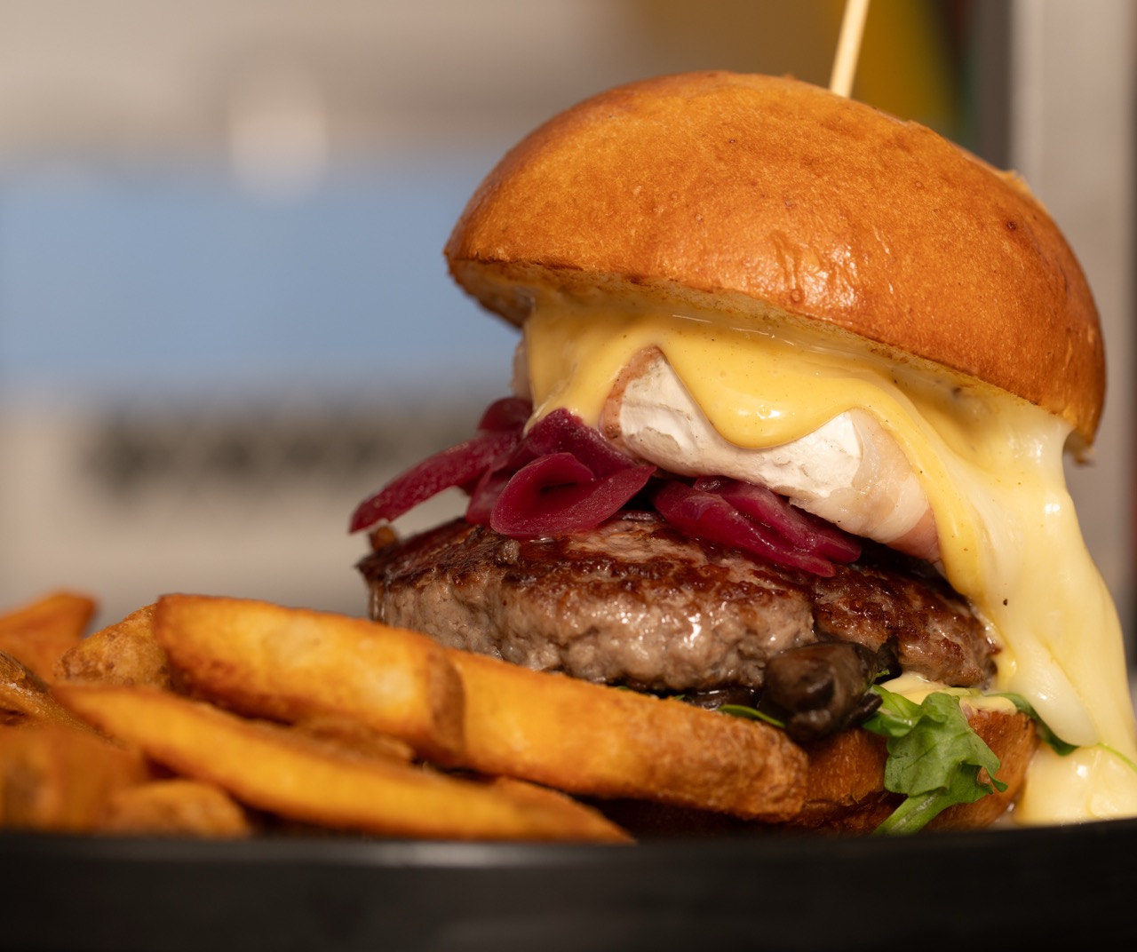 Hamburger gourmet con formaggio fuso e cipolle caramellate