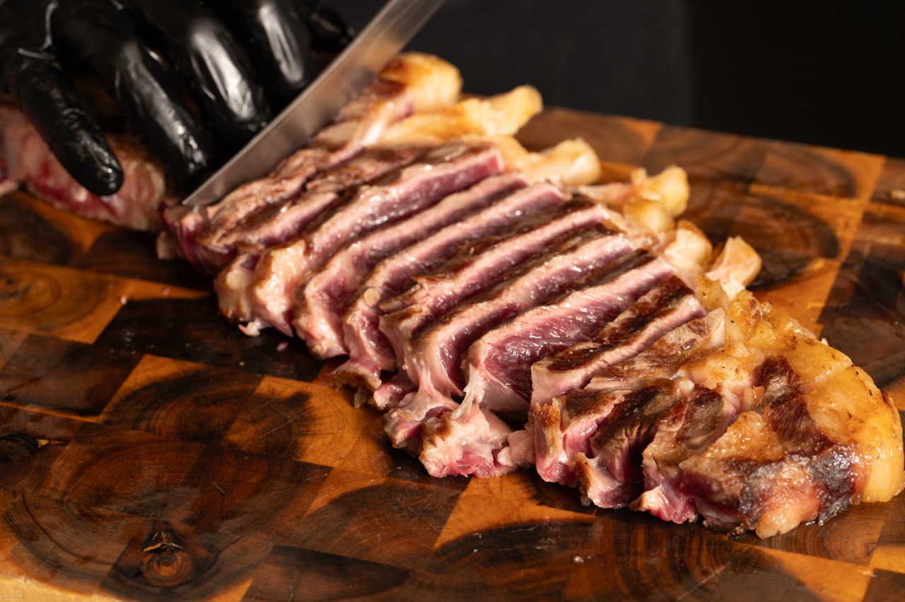 Perfectly sliced steak on wooden cutting board